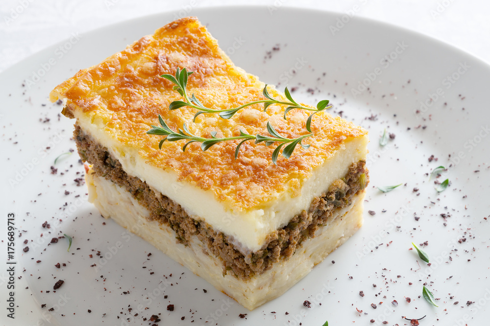 pastitsio piece decorated with thyme and sumac