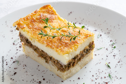 pastitsio piece decorated with thyme and sumac