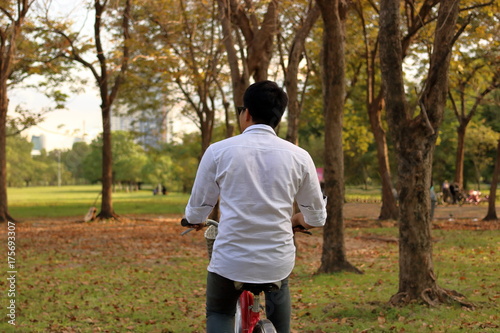 Young man is riding bicycle in the park.