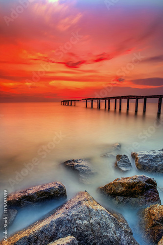 A long Exposure Picture Of abandoned old jetty with  burning sunset as background