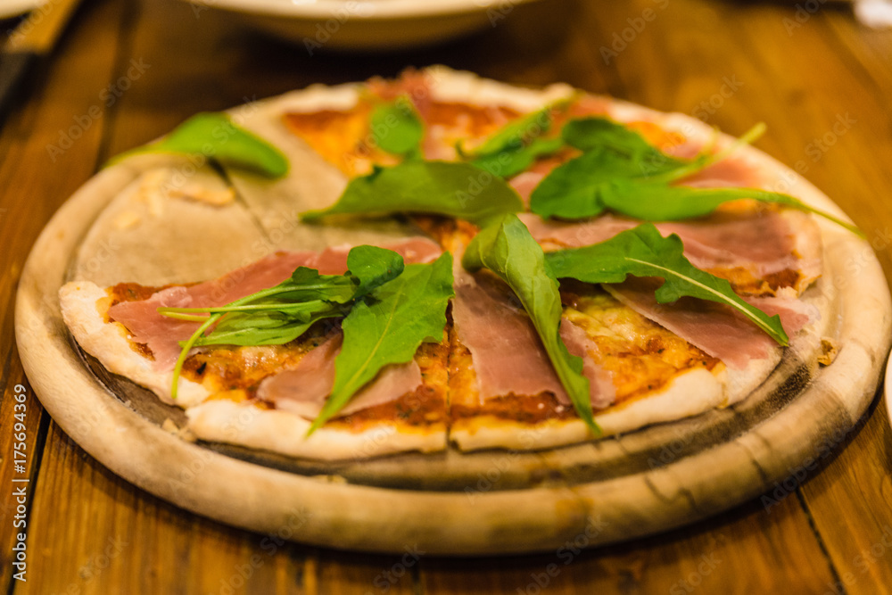 Parma Ham Pizza on rounded wooden plate at the restaurant in Chiang Mai, Thailand. Parma Ham Pizza on rounded wooden plate at the restaurant in Chiang Mai, Thailand.