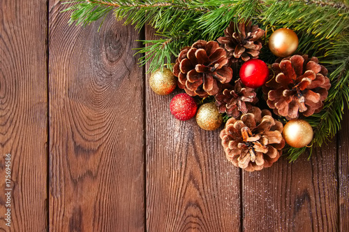 Fototapeta Naklejka Na Ścianę i Meble -  Christmas backdrop. Fir tree branches, christmas balls and cones on a wooden background.