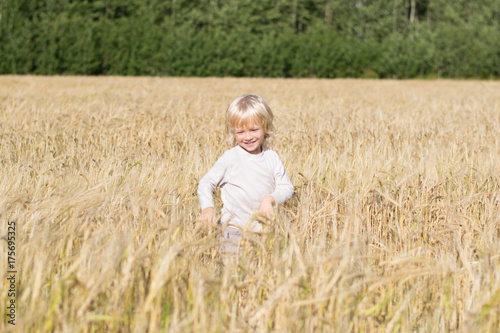 Obraz na płótnie Blond Slavic happy kid boy at a ripe rye wheat field, autumn harvest, Russian forest, the Urals w salonie