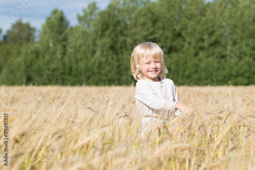 Obraz na płótnie Blond Slavic happy kid boy at a ripe rye wheat field, autumn harvest, Russian forest, the Urals w salonie