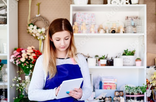 Florist woman taking order online by tablet.