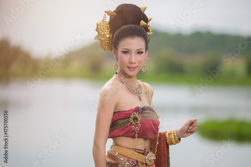 Portrait of  asian woman wearing typical thai dress over river background. © vipubadee