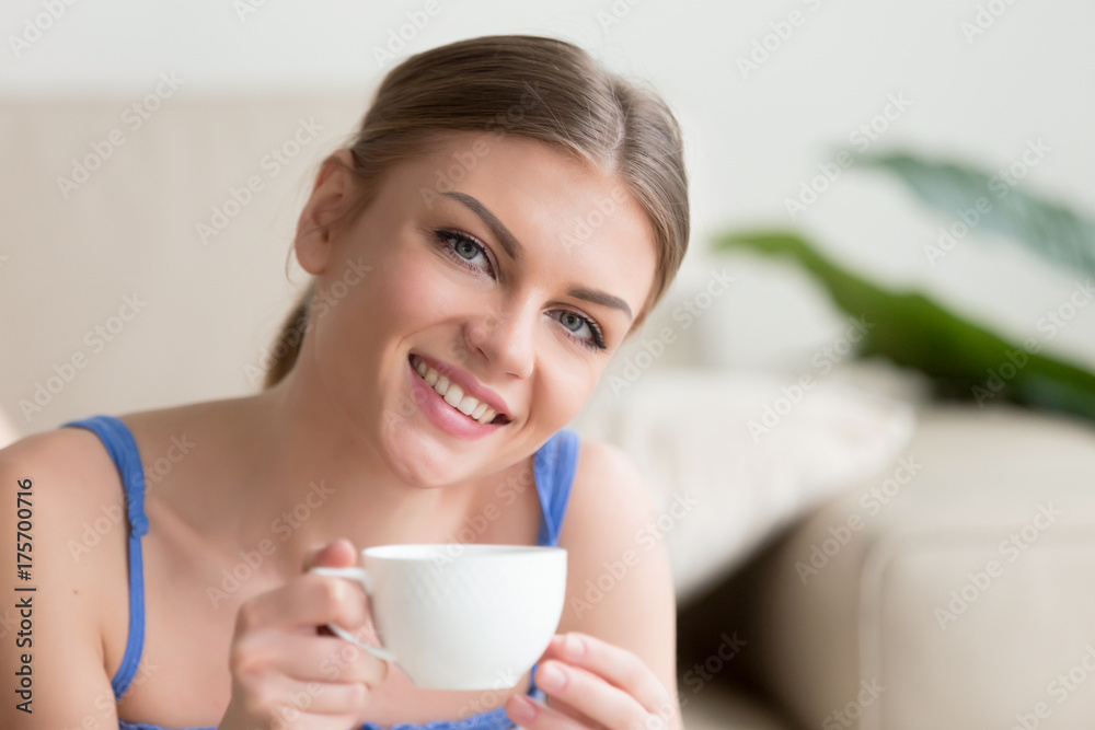 Young smiling attractive woman enjoying instant brewed coffee in the morning, happy lady holding cup of tea and looking at camera, pleasant day at home with hot drink in mug, head shot portrait Young smiling attractive woman enjoying instant brewed coffee in the morning, happy lady holding cup of tea and looking at camera, pleasant day at home with hot drink in mug, head shot portrait