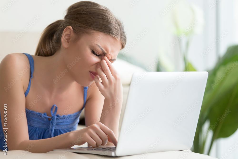 Tired of computer young woman touching nose bridge, feeling headache, suffering from migraine or blurry vision, exhausted teen student having eyesight problems after long work study on laptop