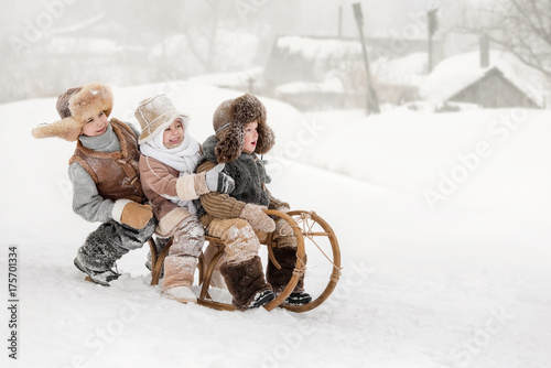 Children slide down hills on sleds