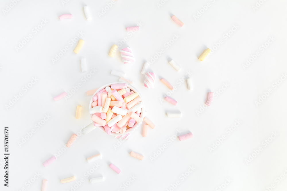Colorful light marshmallows in a cup on white background. Top view, flat lay Colorful light marshmallows in a cup on white background. Top view, flat lay