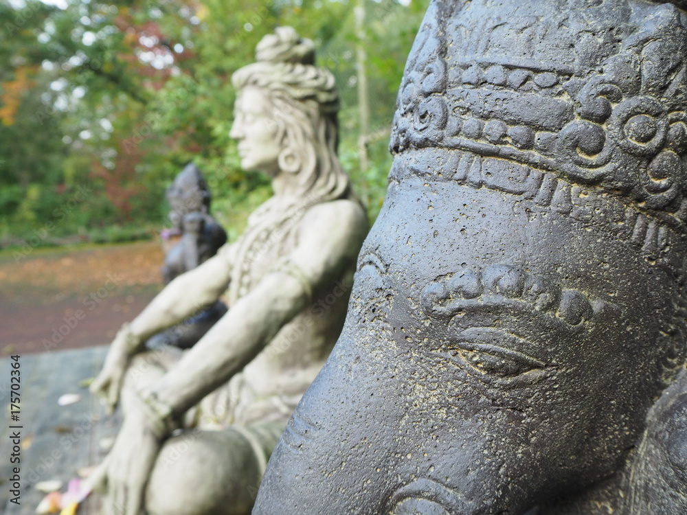 Shiva und Ganesha Statue im Profil aus Stein sitzend auf Holzplattforn