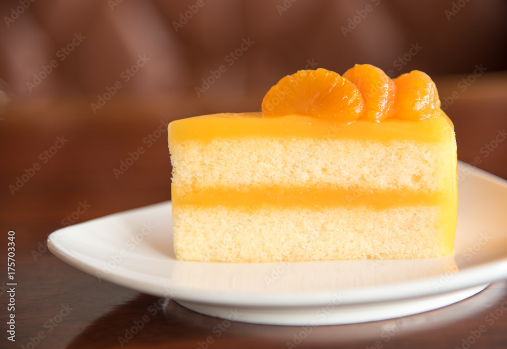 Orange cake on plate with blur brown background Orange cake on plate with blur brown background