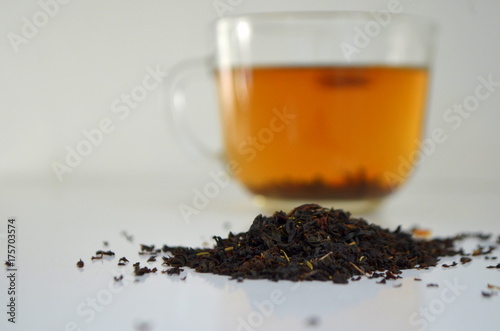Заваренный чай в стекляной прозрачной чашке на белом фоне - лечебный чай с чебреца и лимона