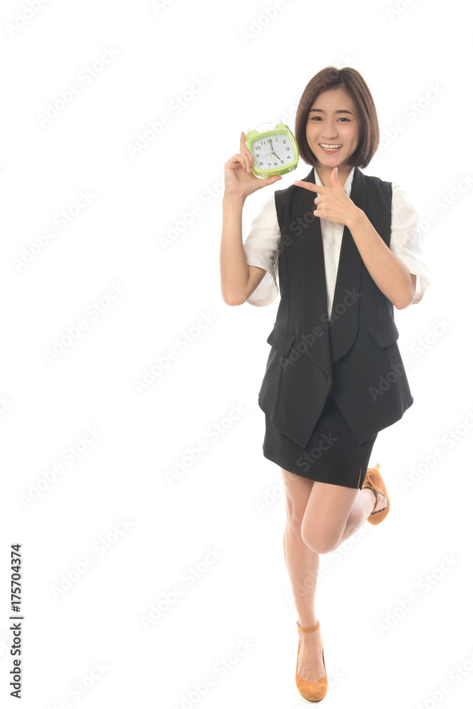 Portrait of asian woman standing and holding alarm clock on pointing at it. Business woman happy when 17.00 pm. on white background. Work out concept. Portrait of asian woman standing and holding alarm clock on pointing at it. Business woman happy when 17.00 pm. on white background. Work out concept.