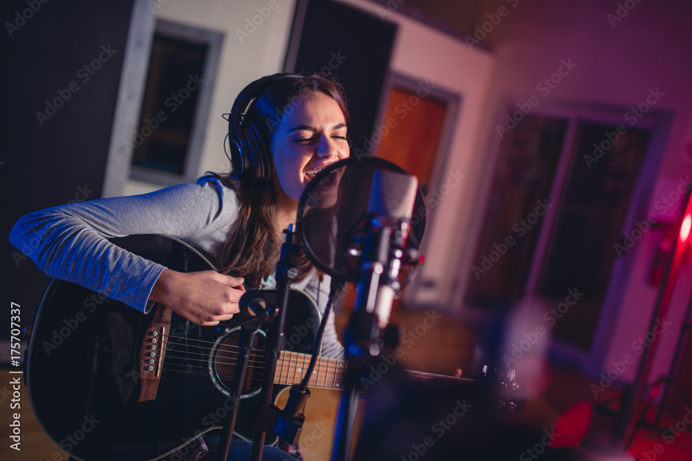 Obraz premium Female vocal artist singing in a recording studio