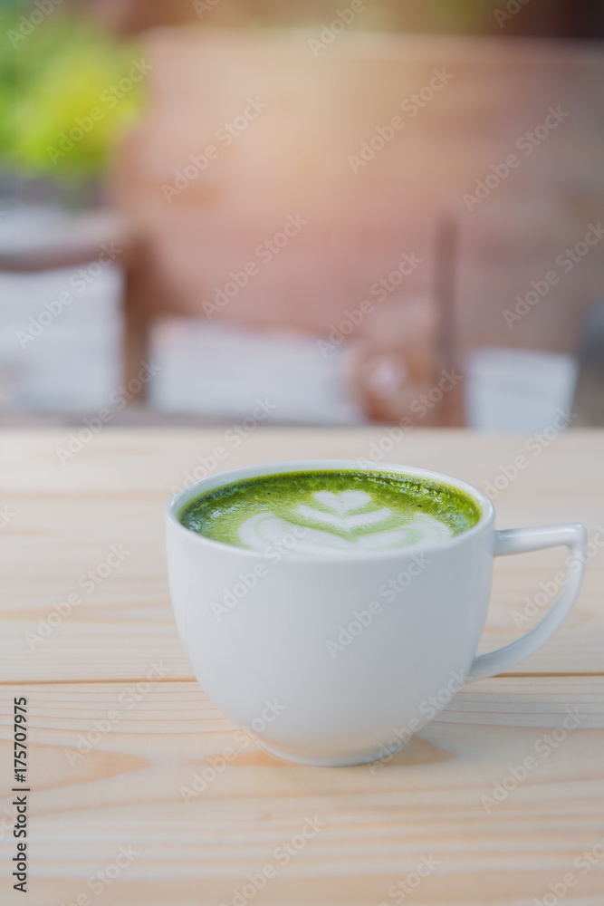cup of green tea on wooden desk in park. cup of green tea on wooden desk in park.