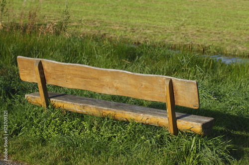 Sitzbank  aus Holz auf einer Wiese photo