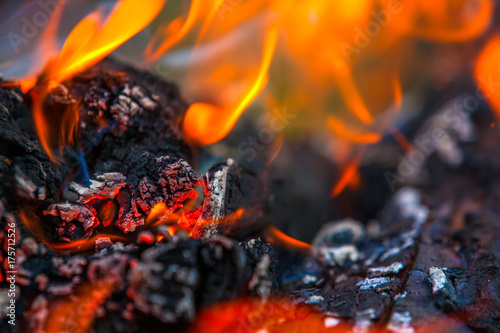 Burning and glowing charcoal with hot flame in the background