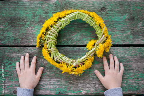 child with a wreath from dandelions photo