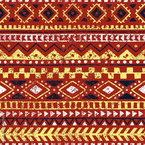 Seamless ethnic pattern. Tribal and aztec motifs. Grunge texture. Orange, yellow, white, brick and blue colors.