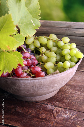 Grapes on wooden table and grape leaves . Healthy fresh fruit wine grapes.