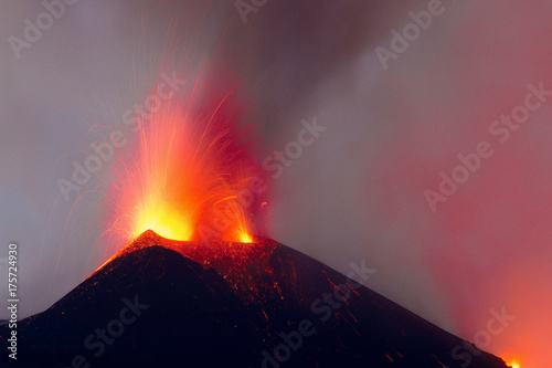 Eruzione stromboliana al cratere attivo centrale del vulcano Etna con esplosione di lava photo