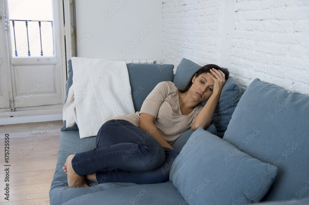 young attractive latin woman lying at home couch worried suffering depression feeling sad and desperate young attractive latin woman lying at home couch worried suffering depression feeling sad and desperate