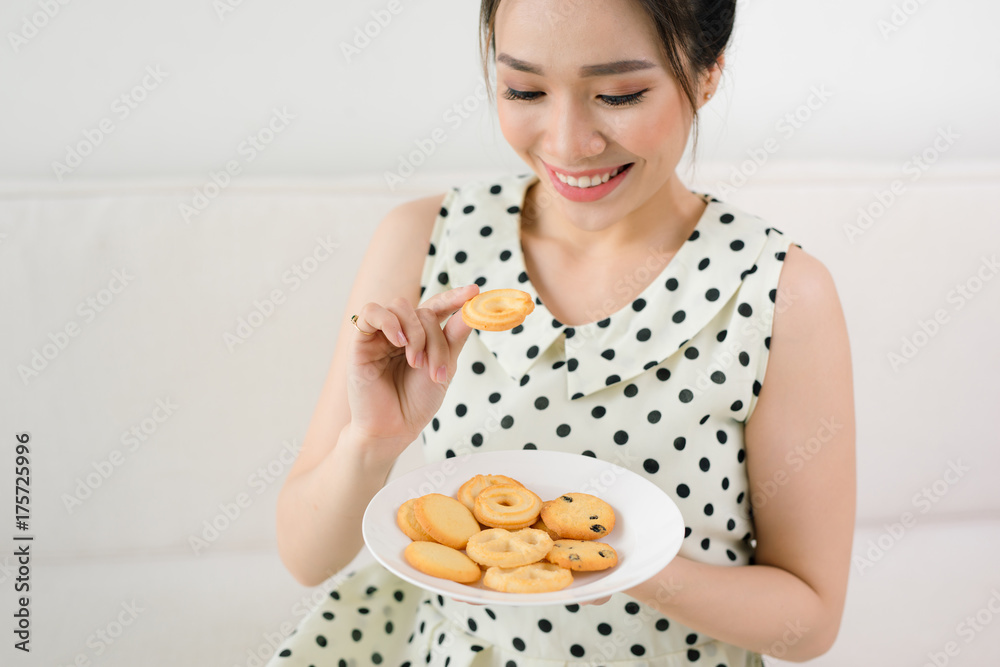 Morning breakfast. Happy girl eating cookie sitting on a couch at home Morning breakfast. Happy girl eating cookie sitting on a couch at home