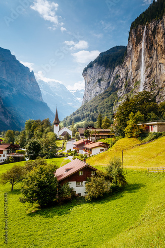 Great view of alpine village glowing by sunlight. Location Swiss alps, Lauterbrunnen valley, Staubbach waterfall, Europe. photo