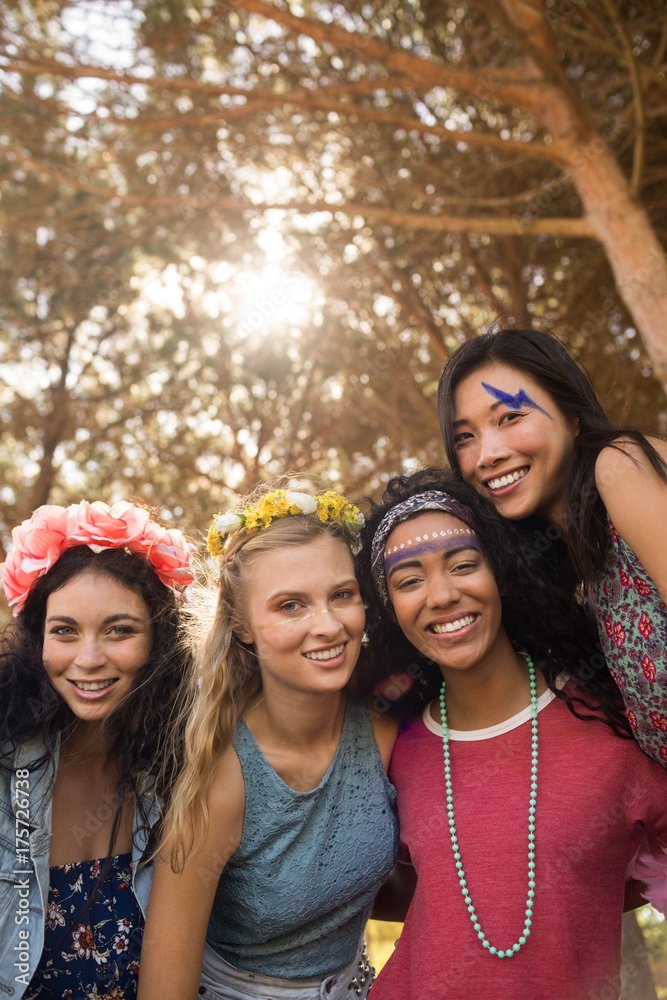 Portrait of smiling young female friends against trees