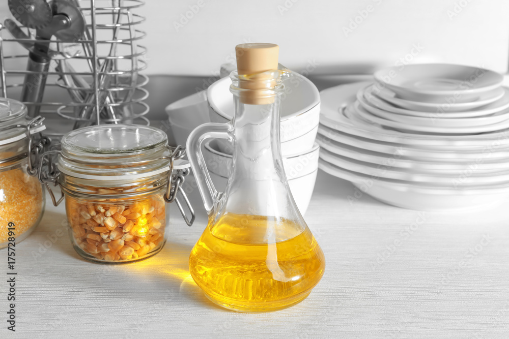 Glass pitcher with corn oil on kitchen table Glass pitcher with corn oil on kitchen table