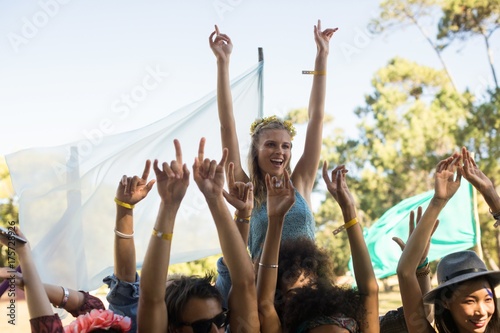 Happy woman with arms raised enjoying at music festival
