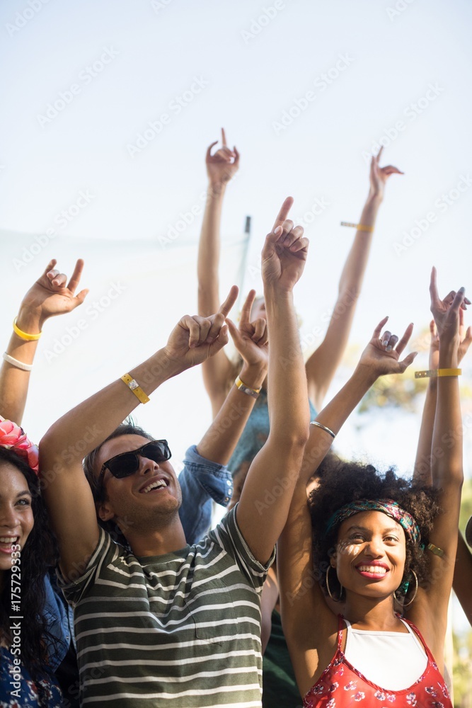 Happy fans dancing with arms raised during music festival Happy fans dancing with arms raised during music festival
