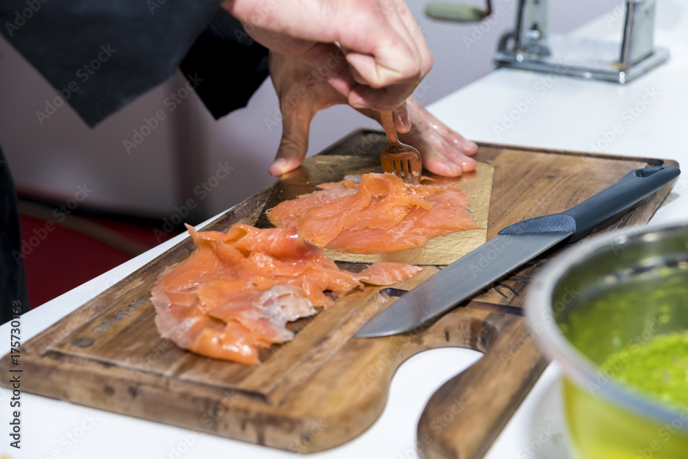 The chef prepares and serves salmon fillets