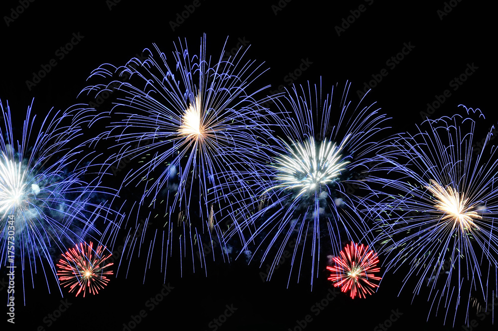 Obraz premium Amazing blue, white and red fireworks on dark background