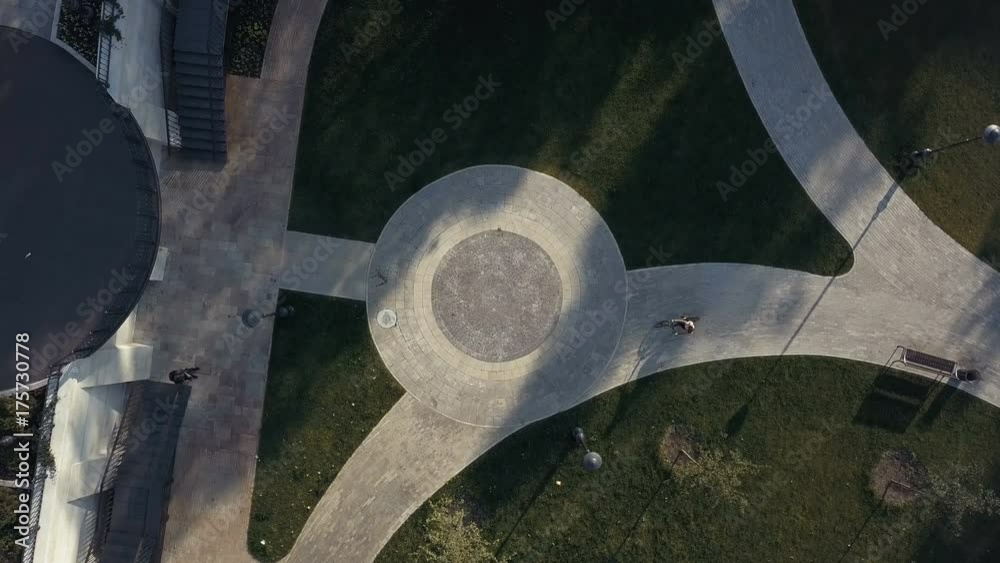Aerial view woman cyclist riding a bike on paved road in city park Aerial view woman cyclist riding a bike on paved road in city park