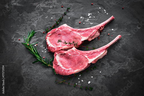 Fotografia raw veal steak on the bone on the dark stone