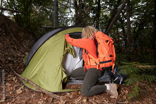 Camping woman in tent using survival knife