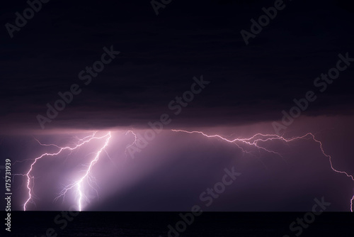 Shot of a lightning strike in the sea during a thunderstorm with heavy rain. Shot is taken at the seaside of the Baltic Sea.