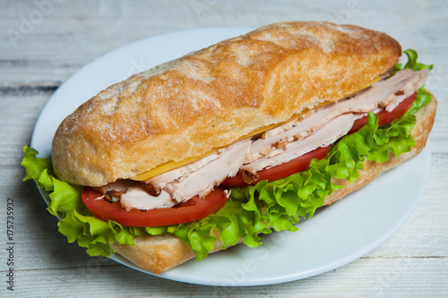 Sandwich with ham, tomato, cheese, onion and lettuce isolated on white background. Big sandwich with meat and cheese