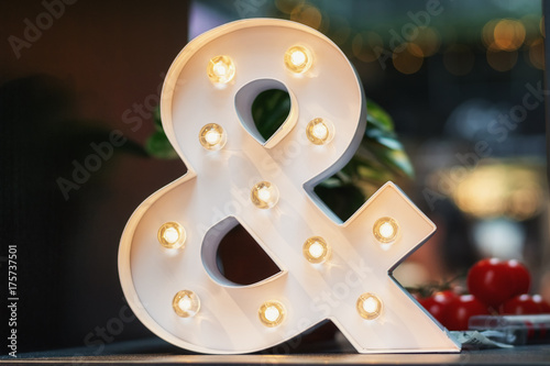 A huge illuminated ampersand on the table