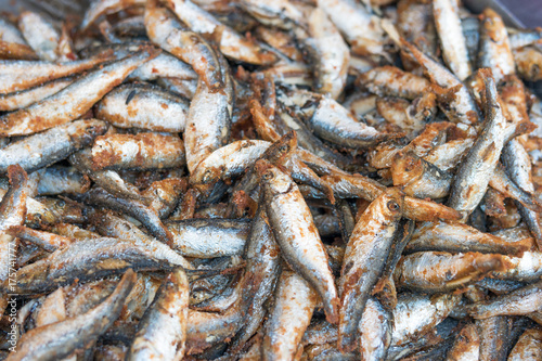 Fried small fish on a fair stall, selective focus