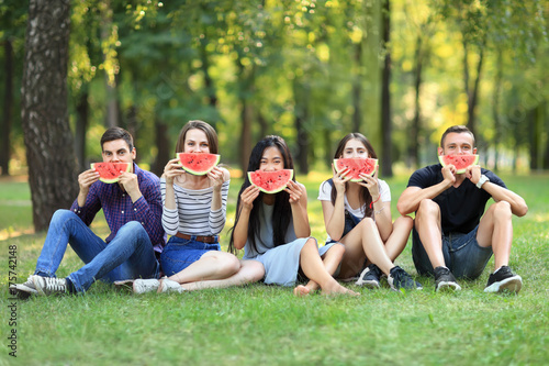 Fototapeta Naklejka Na Ścianę i Meble -  Funny men and women covering faces with tasty watermelon slices