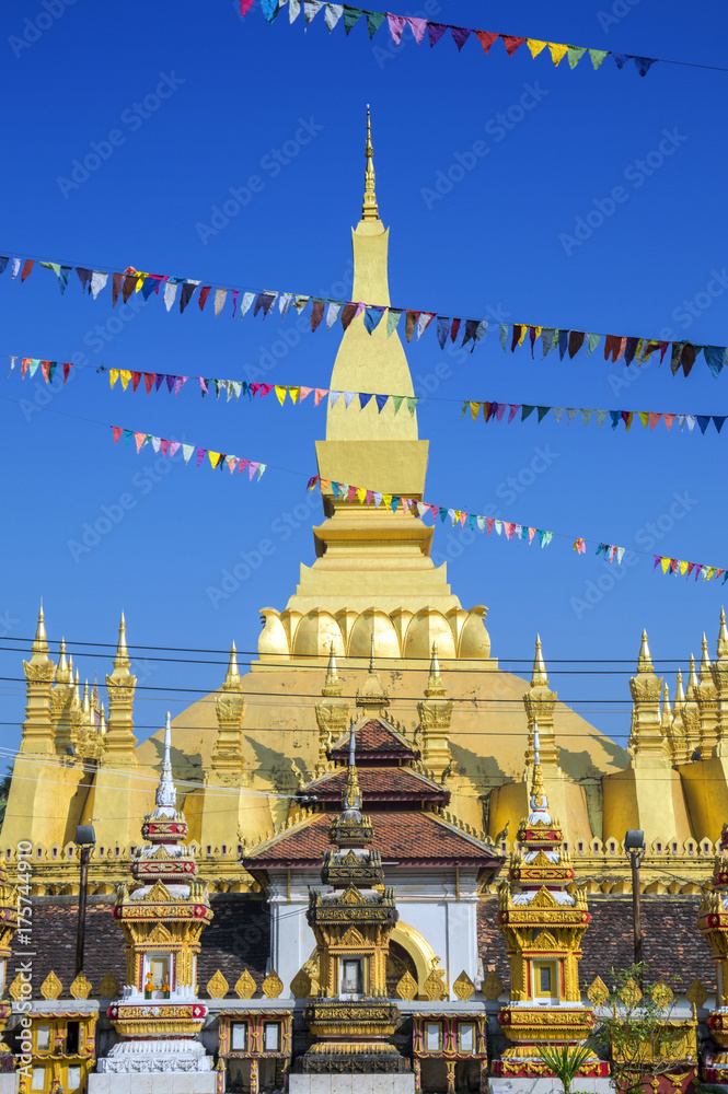 Fototapeta premium That Luang Stupa, landmark of Vientiane, Lao PDR, decorated with colourful pennant banners during annual celebration of Boun That Luang Festival