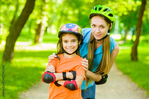 Portrait of mother and daughter in protective helmets for roller skating