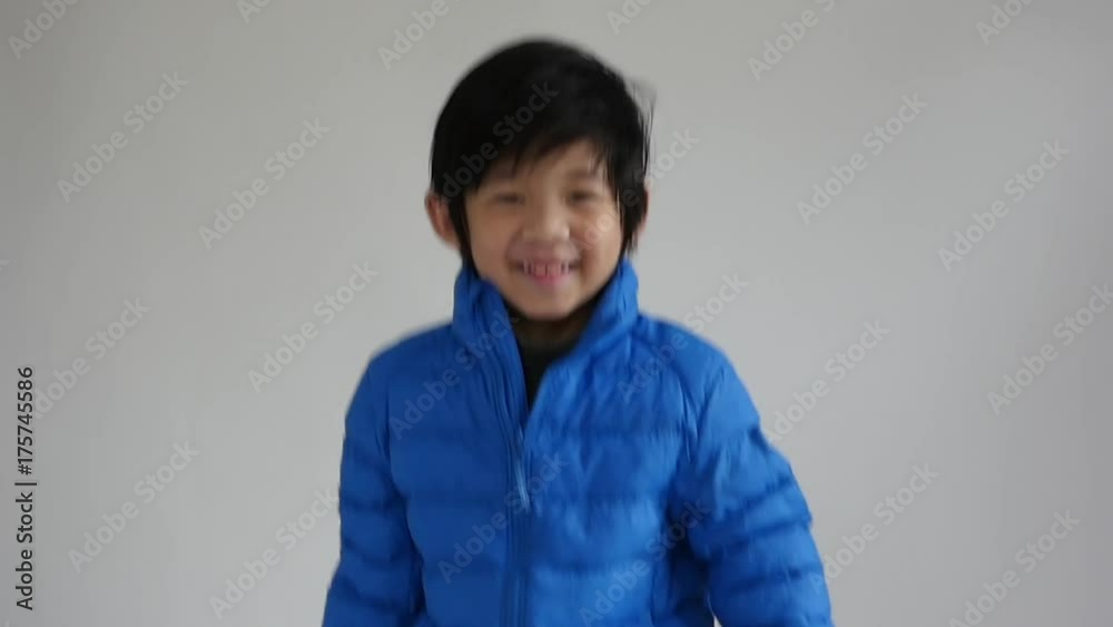 Happy asian child in blue winter clothes standing slow motion Happy asian child in blue winter clothes standing slow motion