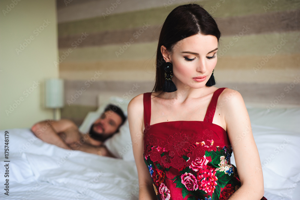 Fototapeta premium Couple in bed, portrait of a sad woman in bed with her husband
