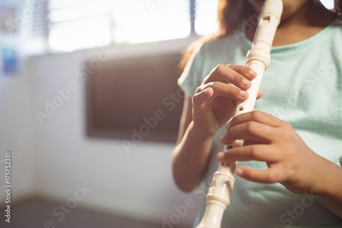 Fotografia, Obraz Mid section of girl playing flute in classroom