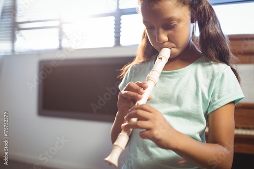 Fototapeta Girl practicing flute in class