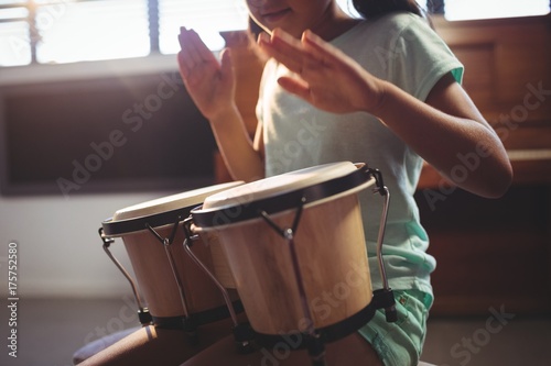 Mid section of girl playing bongo drums photo